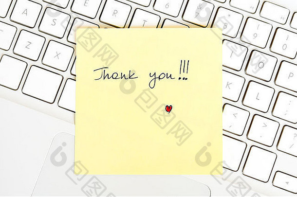 在笔记本电脑键盘上安排了一张写着“谢谢”的便条
