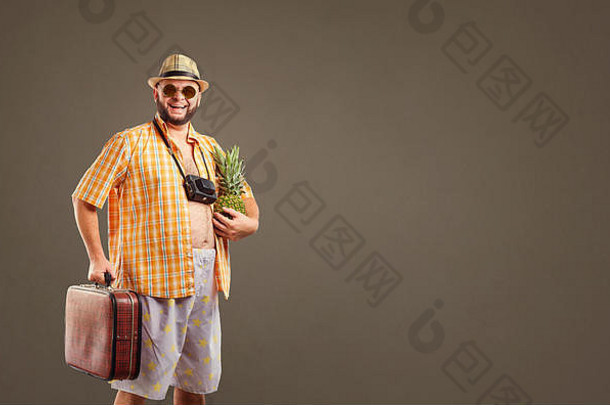 一个滑稽的留着大胡子的游客，带着一个菠萝和一个微笑的手提箱