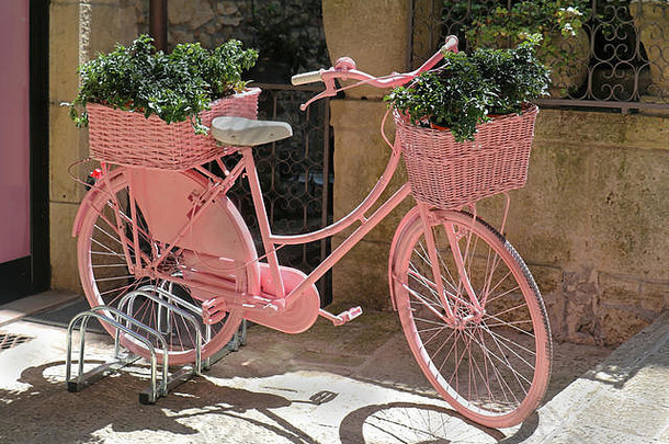 复古少女般的粉红色自行车，外面街道上有花篮