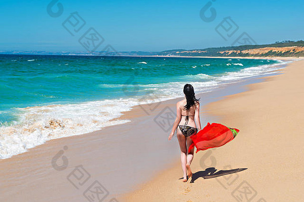 站在海滩上享受阳光的年轻女子