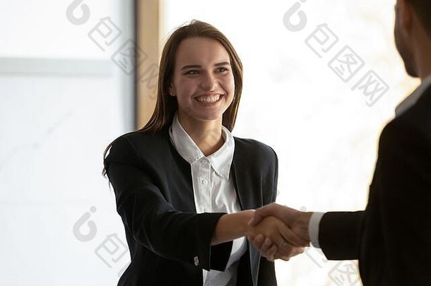 快乐的年轻女员工与同事握手。