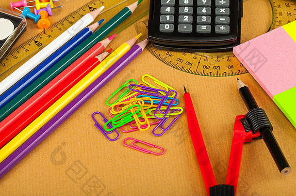 学校学习工具-笔记本、钢笔、剪刀、计算器、尺子等-木制背景