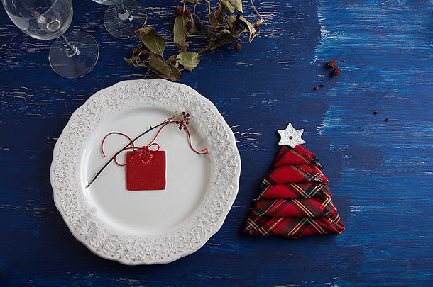 圣诞晚餐质朴，白色盘子，餐巾纸红色盒子，树形，<strong>蓝色</strong>背景