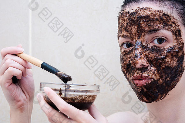 年龄在20-29岁之间的白人模特用咖啡洗面奶洗脸和眼袋。