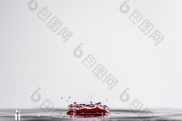 明亮的红色水滴和涟漪被隔离在干净的背景上