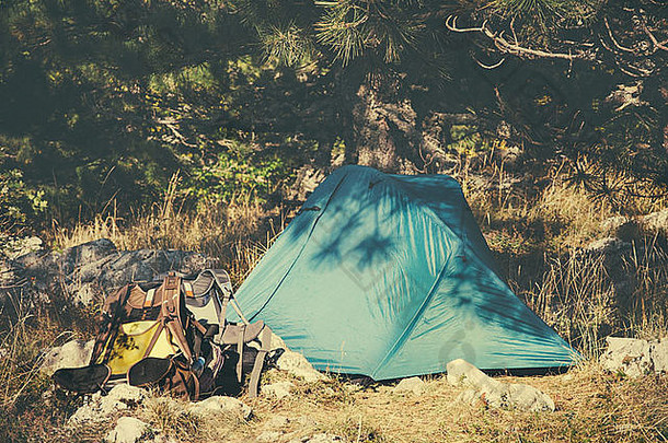 帐篷露营和旅游设备背包，户外，以夏季自然为背景，电影效果复古色彩