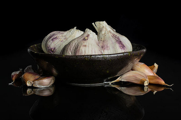 集团很多块有机白色大蒜葱属植物一种黑暗陶瓷碗孤立的黑色的玻璃