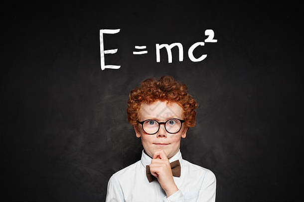 小天才肖像。用科学公式写在黑板上的小男孩