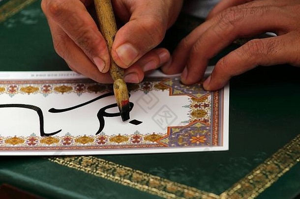 摩洛哥马拉喀什。用传统木制书法笔和黑色墨水书写的书法特写。