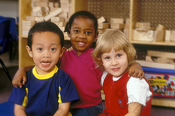 一群种族混杂的孩子坐在游戏室的地板上