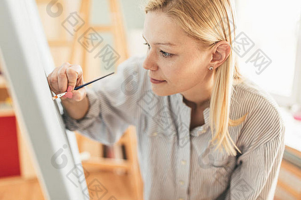 美丽的女人艺术家绘画刷油漆艺术工作室