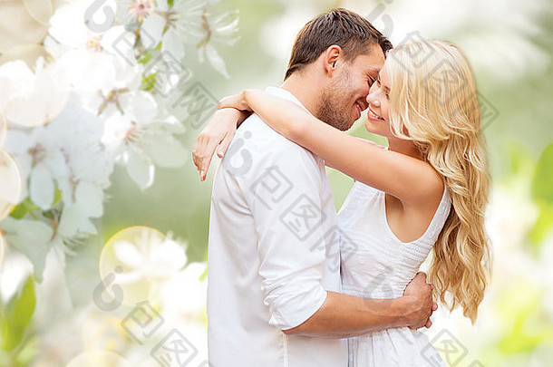一对幸福的夫妇在盛开的夏季花园里拥抱
