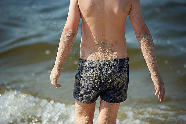 夏天，金发男孩在沙滩上玩耍