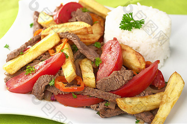 秘鲁菜被称为腰跳过使番茄牛肉肉洋葱混合法国薯条服务大米