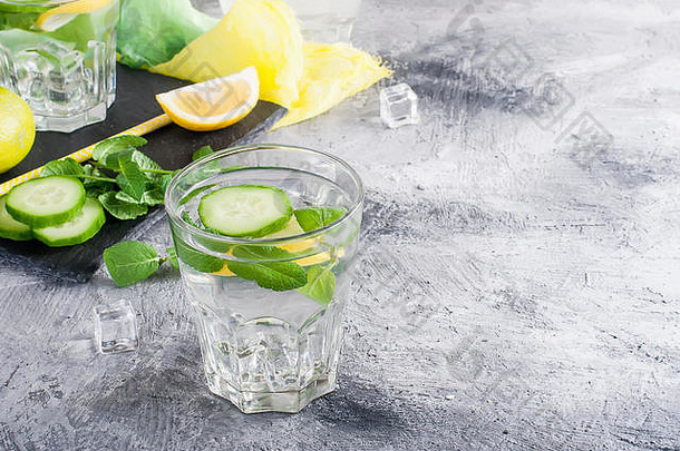 清爽的黄瓜鸡尾酒、柠檬水、解毒水装在灰色背景的玻璃杯中。夏日饮料。俯视图
