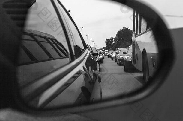 在侧视镜中反映交通堵塞。应用旧黑白摄影滤镜