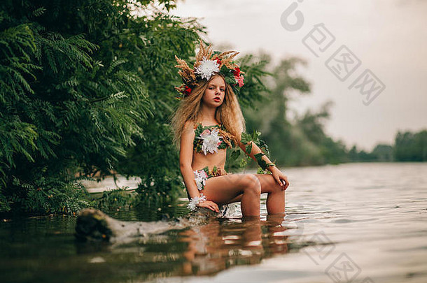 画中美丽的小女孩戴着花环坐在<strong>水中</strong>的树干上。她的倒影在水里。