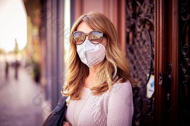 冠状病毒疫情科维德脸面具预防避免触碰触摸流感大流行保护女商人女人移动电话