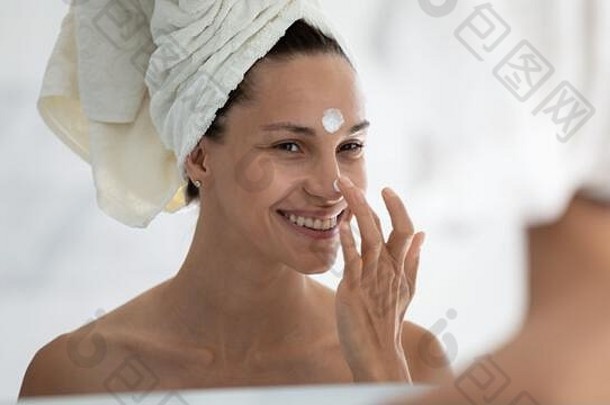 女士在脸部特写上涂抹day面部保湿霜