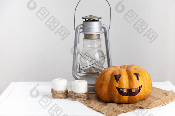 白色木桌上的南瓜、蜡烛和灯笼。秋季万圣节的概念。乡村风格