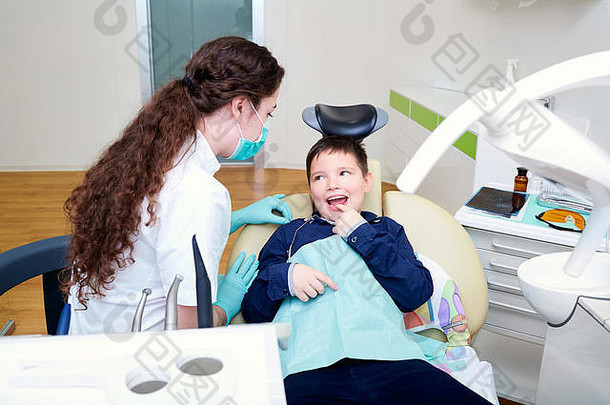 和女医生坐在牙医椅上的孩子