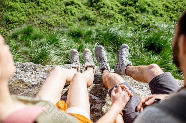 一对年轻夫妇在山上旅行时穿着登山鞋的腿