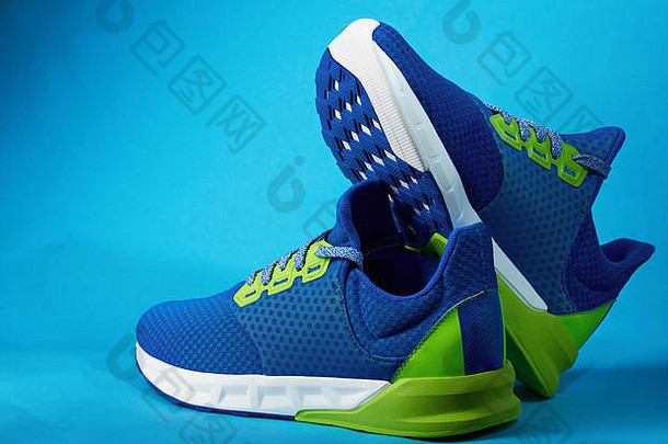 店内陈列的新运动鞋与蓝色背景隔离。蓝色彩色跑鞋