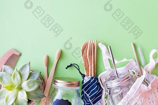 零废物概念。绿色背景上的棉袋、竹餐具和牙刷、玻璃罐、金属和竹吸管。可持续生活。生态薯条
