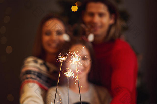 美丽的家庭欢庆圣诞节，手拿火花