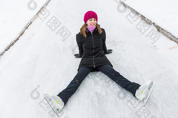 坐在冰上微笑的滑冰女子。