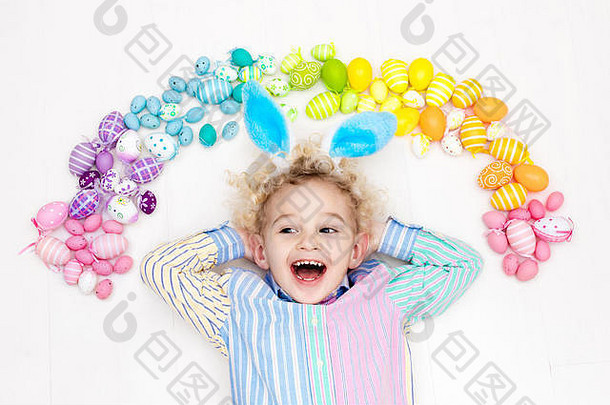 有<strong>兔</strong>子耳朵的有趣小男孩在寻找复活节彩蛋时玩得很开心。玩彩色复活节彩蛋的孩子。孩子们玩彩色彩虹蛋。Spr