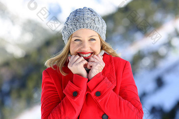 前面视图肖像快乐时尚女人保持温暖的穿红色的外套冷冬天雪山