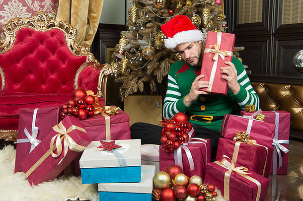 没<strong>有礼</strong>物就没有完整的圣诞节。带着圣诞礼物盒的快乐男人。戴圣诞帽的人拿着圣诞礼物。盖伊正在家里庆祝圣诞节。<strong>送</strong>圣诞礼物。
