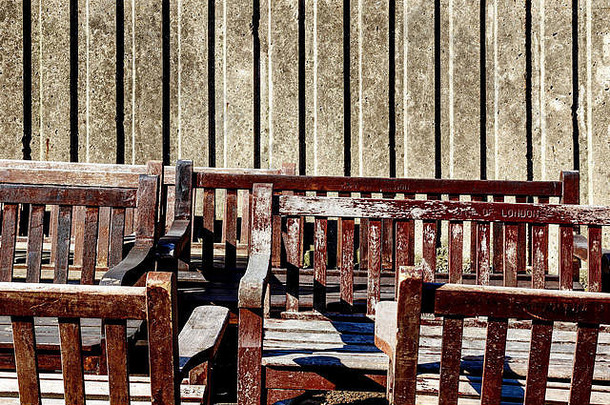 被遗弃的木长椅刻城市伦敦堆混凝土墙