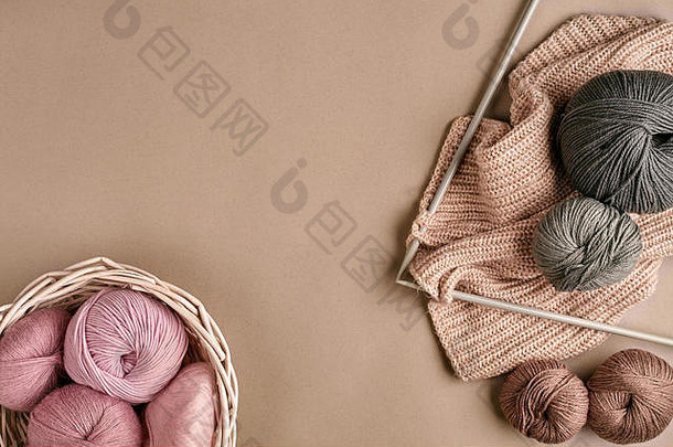 美利奴毛线球，在米<strong>色</strong>表面的针织针上编织。俯视图