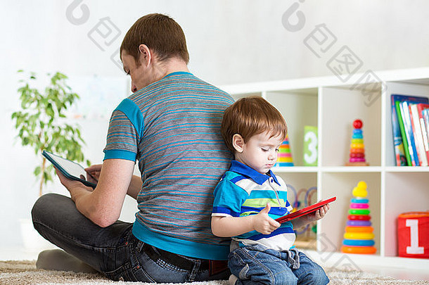 孩子和父亲在家玩平板电脑的孤独感