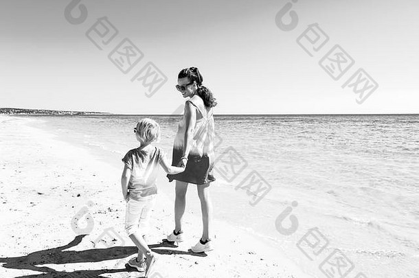 色彩斑斓的惊人的快乐的情绪现代妈妈。女儿色彩斑斓的衣服海滩走
