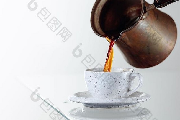 玻璃桌上的陶瓷杯中的黑咖啡。咖啡从咖啡机倒进杯子里。空间。