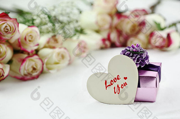 礼品盒和爱你木制心形卡片，背景是一束美丽的红白<strong>玫瑰</strong>。使用selecti的浅景深