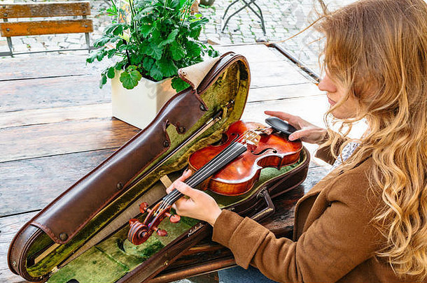 女人的手拿着旧小提琴以防万一特写