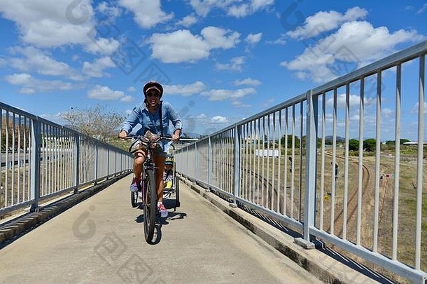 澳大利亚昆士兰州汤斯维尔，一名妇女骑着一辆儿童自行车拖车