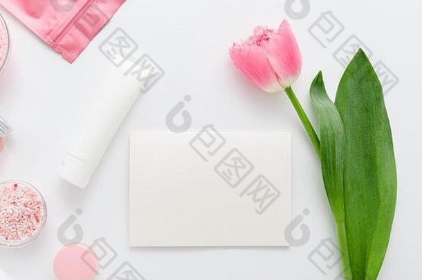 白色背景上有粉红色郁金香花的天然有机化妆品。白色空白卡片，带有文本空白。美容、沐浴用天然化妆品