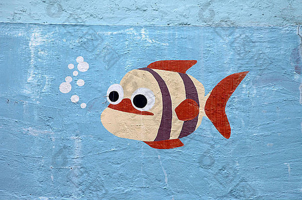 这是一张画着一条有趣的鱼的照片。他有一双大眼睛，在蓝色的海水或海洋中游泳，它在墙上