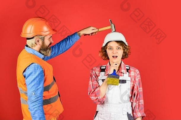 可理解的概念。夫妻俩一起装修公寓。男人和女人都戴安全帽。夫妻俩在家修理。家庭装修。磨合。用锤子敲击头部。解释清楚。