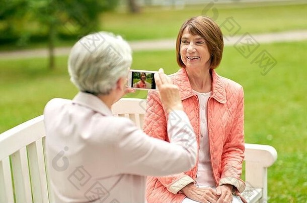 老妇人在公园给她的朋友拍照