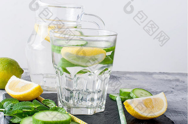 清爽的黄瓜鸡尾酒、柠檬水、解毒水装在灰色背景的玻璃杯中。夏日饮料。