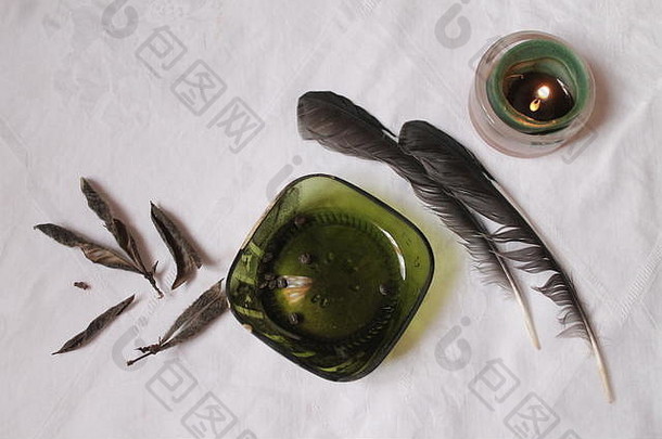两只鸟的羽毛、豆子和燃烧的绿色蜡烛有利于萨满之旅