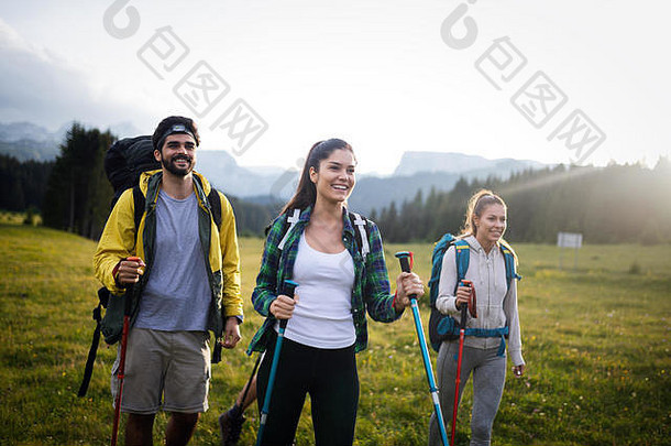 一群背着背包和棍子在山上行走的徒步旅行者。远足的朋友