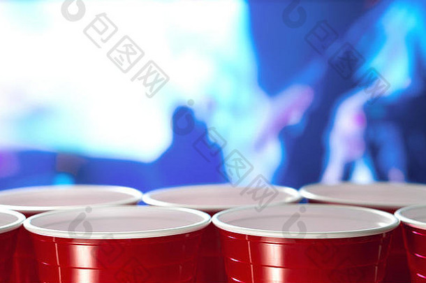 在一家夜总会里，塑料<strong>红色</strong>派对杯排成一排，人们在舞池中跳舞。非常适合营销和<strong>推广</strong>。