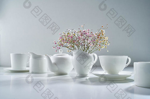 白色陶瓷茶具，浅灰色背景，带有精致的花束